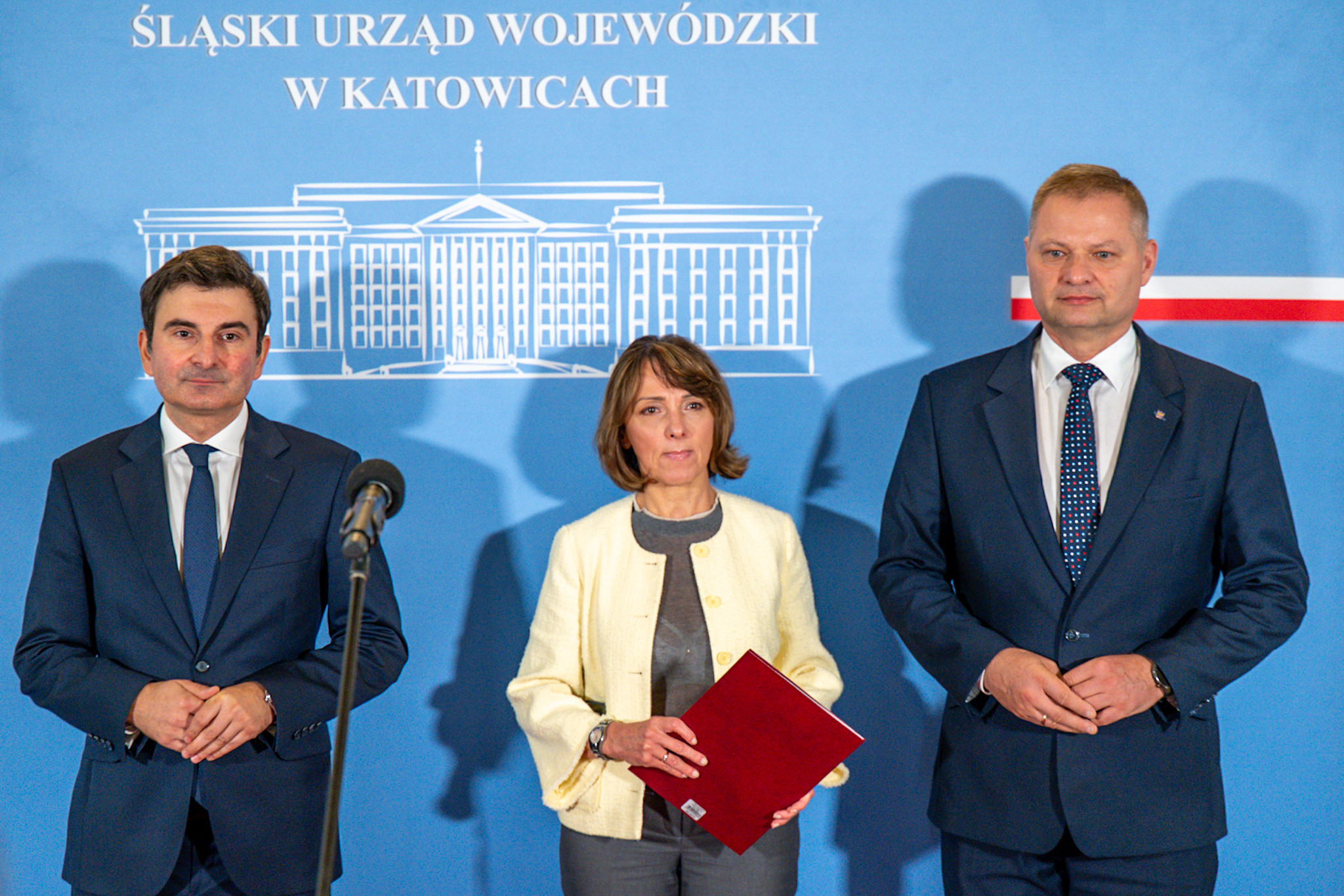 Wojewoda Śląski, Śląska Kurator Oświaty i Członek zarządu województwa śląskiego stoją na tle ścianki prasowej.