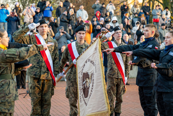 Uczniowie ślubują stojąc przy sztandarze.